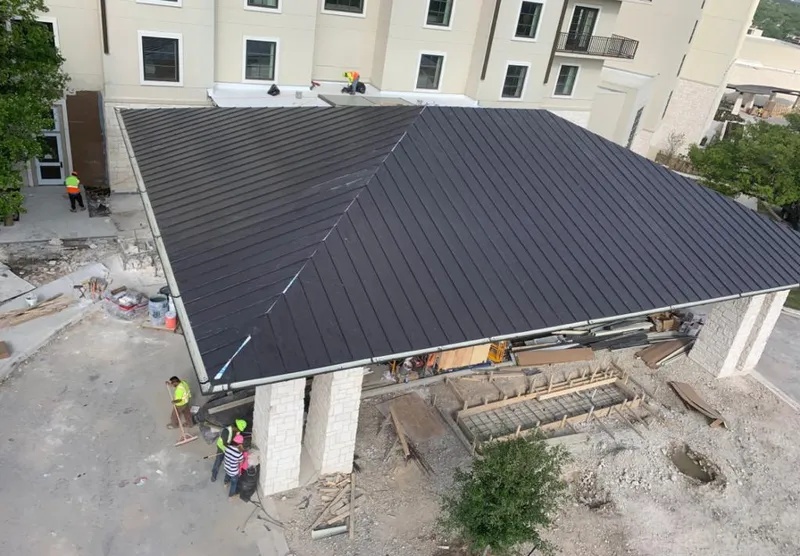 Metal roofing installation team working on a commercial building in Sheldon